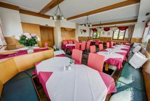 una sala da pranzo con tavoli e sedie rosa di Gasthof Neuwirt / Kressnig a Klagenfurt