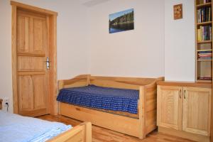 1 dormitorio con cama y estante para libros en Apartman Razula, en Velké Karlovice