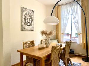 a dining room table with chairs and a lamp at Appartement Scheepers in Valkenburg