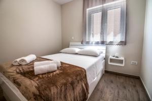 a bedroom with a bed with white sheets and a window at Apartment Aurea in Primošten +85 photos