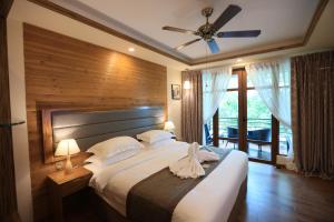 1 dormitorio con 1 cama grande y ventilador de techo en Pearl Sands of Maldives en North Male Atoll