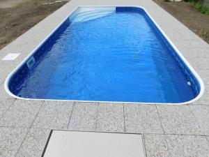 uma piscina com água azul num pátio em Pension U Mojmíra em Rokytnice nad Jizerou