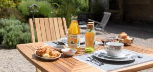 uma mesa com pão e uma garrafa de vinho e bebidas em Le Manoir De Juganville em Saint-Martin-de-Varreville