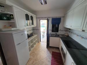 une cuisine avec des armoires blanches et des comptoirs noirs dans l'établissement Algarve Villa Albufeira Altos dos Caliços, à Albufeira