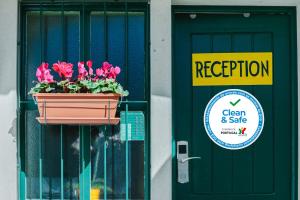 una puerta con una maceta de flores rosas junto a una señal en Ljmonade Hostel, en Cascais