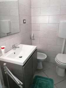 a bathroom with a sink and a toilet and a mirror at Il Patio Alghero in Santa Maria la Palma