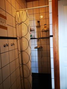 a shower in a bathroom with white tiled walls at Hardanger Kulturgalleri in Herand