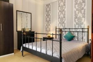- une chambre avec un lit noir et un miroir dans l'établissement Magda Rooms ''Sea View'', à Neos Marmaras