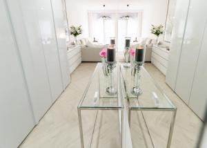 szklany stół w białym pokoju z kwiatami w obiekcie BIANCO APARTMENTS w Świnoujściu