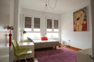 een slaapkamer met een bed, een bureau en een raam bij Bohemia en El Centro de Malaga in Málaga