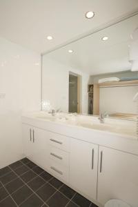 baño con 2 lavabos y espejo grande en Maclin Lodge Motel, en Campbelltown