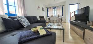 een woonkamer met een bank en een televisie bij Casa Yaiza in Playa Blanca