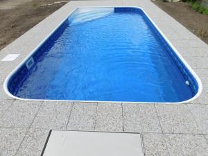 einen blauen Pool auf einer Terrasse in der Unterkunft Pension U Mojmíra in Rokytnice nad Jizerou