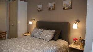 sypialnia z łóżkiem i 3 zdjęciami na ścianie w obiekcie Les petits nids de Nina 1 w mieście Fosses-La-Ville