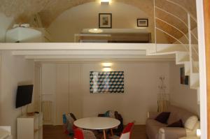 ein Wohnzimmer mit einem Tisch und einem Bett in der Unterkunft Profumo Di Gelsomino in Scicli