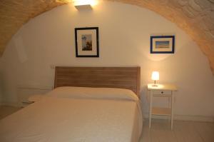 a bedroom with a bed and a table with a lamp at Profumo Di Gelsomino in Scicli