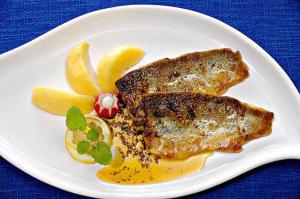 a plate of food with fish and fruit on a table at Waldgasthof Altersbach in Waldkirch