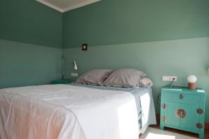 een slaapkamer met een wit bed en een blauwe kast bij Bohemia en El Centro de Malaga in Málaga