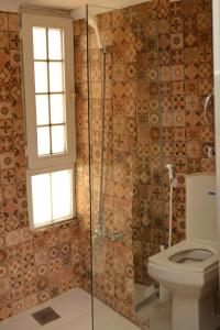 a bathroom with a toilet and a glass shower at Cairwan Hotel in Kerak +81 photos