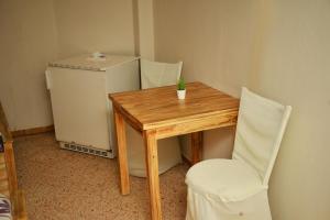 a small table and chair next to a small refrigerator at Cairwan Hotel in Kerak