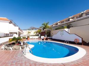a swimming pool in the courtyard of a hotel at Fewo Jacqui in Los Cristianos