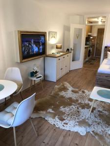 salon z telewizorem, stołem i krzesłami w obiekcie Apartment Haus Föhrenwald w mieście Seefeld in Tirol