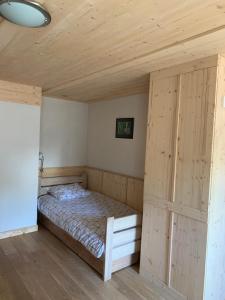 a bed in a room with a wooden ceiling at Gîte Côté Verre in Meisenthal