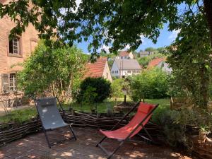 zwei Stühle auf einer Terrasse unter einem Baum in der Unterkunft Gîte Côté Verre in Meisenthal