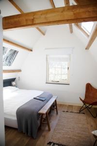 弗利蘭的住宿－B&B "Jan" te Vreeland，卧室配有床、椅子和窗户。