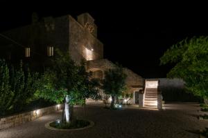 a large stone building at night with trees and lights at Galeta Masseria in Nardò