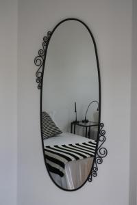 a mirror with a black frame on a white wall at Hostel Rossio Alcobaça in Alcobaça