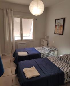 a room with three beds and a window at Belle villa sur vaste plage Palavas Montpellier in Palavas-les-Flots