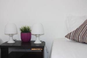 a bedside table with two lamps and a plant on it at Hostel Rossio Alcobaça in Alcobaça