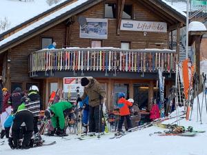 un grupo de personas de pie fuera de un lodge de esquí en Haus am Sonnenberg,Todtnauberg, Ferienwohnung 002, direkt am Skilift-Skipiste, Nähe Feldberg, en Todtnauberg