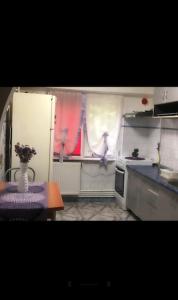 a kitchen with a table and two people in the window at WLD House in Constanţa