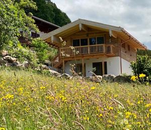 dom na wzgórzu z polem kwiatów w obiekcie Chalet Ruhpolding Bayern w mieście Ruhpolding