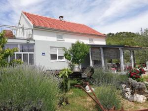 a white house with a red roof at Apartmani Goga in Skradin