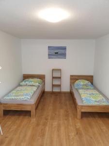 2 Betten in einem Zimmer mit Holzböden in der Unterkunft HummelHaus 3 in Lindau in Lindau