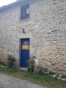 eine blaue Tür in einem Steingebäude mit einem Schild darauf in der Unterkunft Fée maison with love appartement in Cuissai