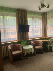a waiting room with two chairs and a table and windows at Hotelik in Chełmno +45 photos