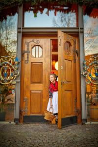 una niñita parada dentro de una puerta en Hotel Landgraf en Schwalmstadt