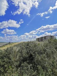 un edificio situado en lo alto de una playa de arena en Hotel de Milliano, en Breskens