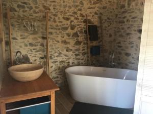 a bathroom with a large white tub and a sink at LA GRANDE THIBAUDIERE in La Plaine