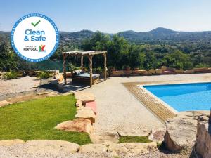 una villa con piscina y un cartel que diga limpio y seguro en Villa Monte da Alfarrobeira en Estói
