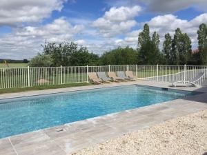 a swimming pool with chairs and a fence at LA GRANDE THIBAUDIERE in La Plaine