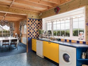 a kitchen with a sink and a washing machine at Ballyheigue Guesthouse in Heirhill