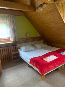een slaapkamer met een groot bed en een rode deken bij Hotelik in Chełmno