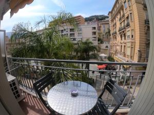 a table and chairs on a balcony with a view of a city at République n°1 in Beausoleil