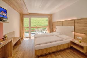 ein Schlafzimmer mit einem großen Bett und einem großen Fenster in der Unterkunft Oberjahrl in St. Johann im Ahrntal