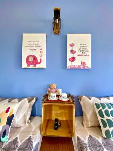 a room with a bed with a table and two posters at Duy Tan Home in Quy Nhon